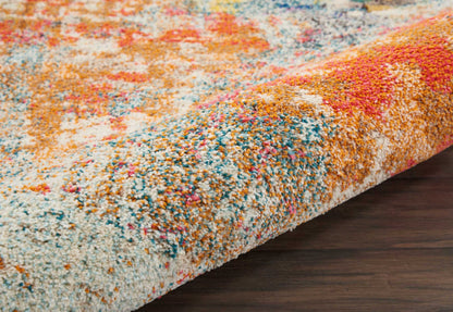 Colorful high-pile shag rug with orange, blue, pink, white and yellow tones; plush abstract pattern on dark wood floor.