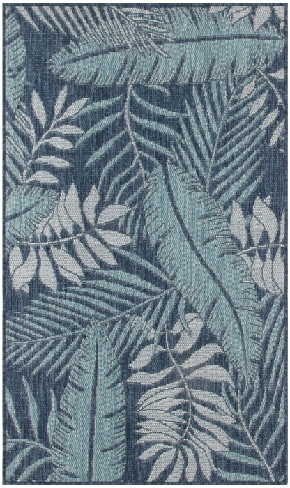 Rectangular blue tropical leaf rug with woven texture and layered palm fronds in light and dark blue tones.