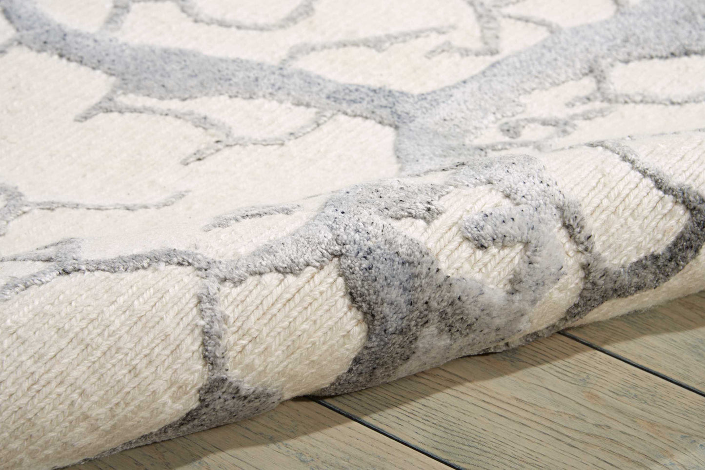 Ivory & gray stone-pattern area rug with soft plush pile on light wood floor.