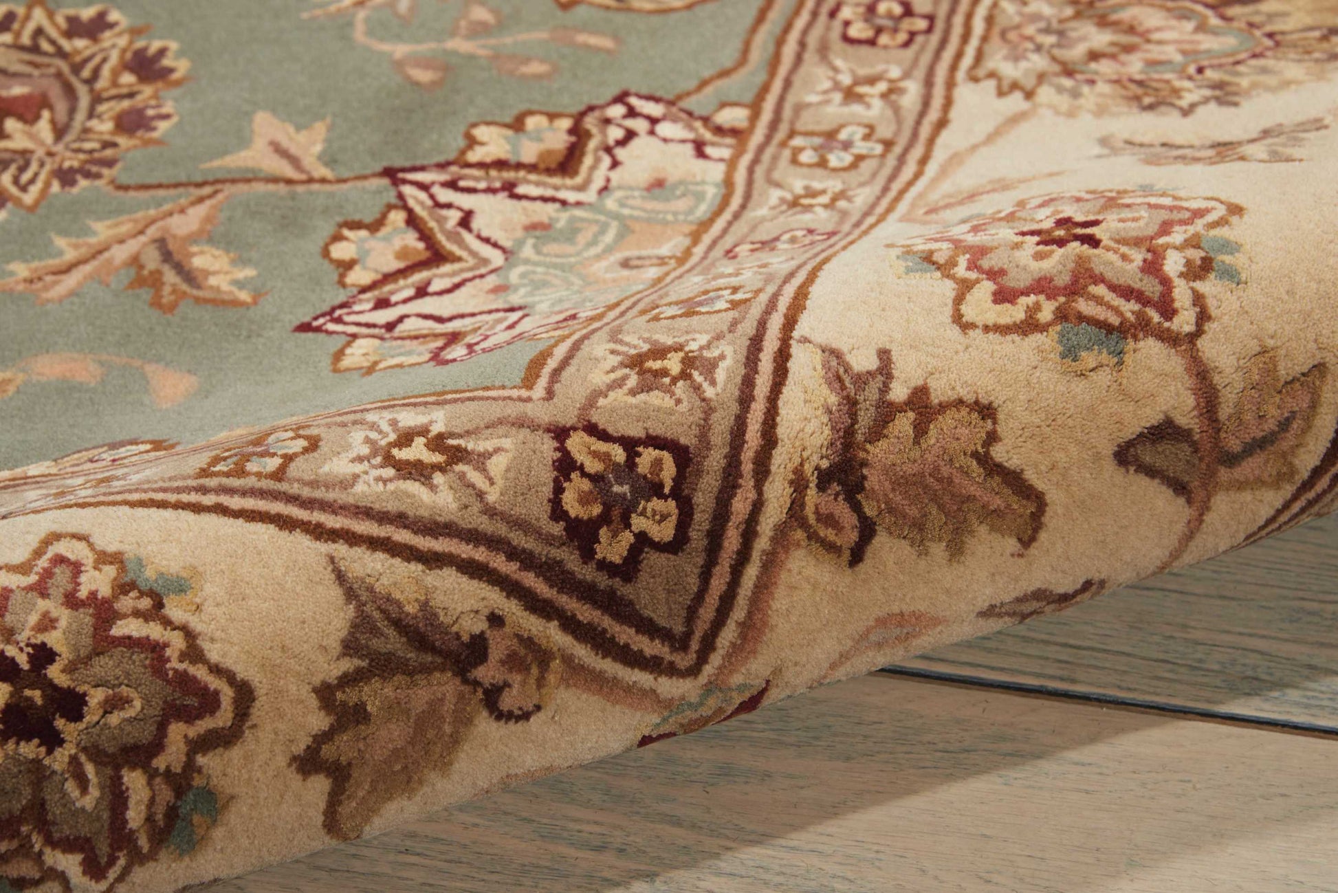 Traditional floral runner rug, 8' long, in cream, beige, sky blue & burgundy border; folded corner shows woven pile.