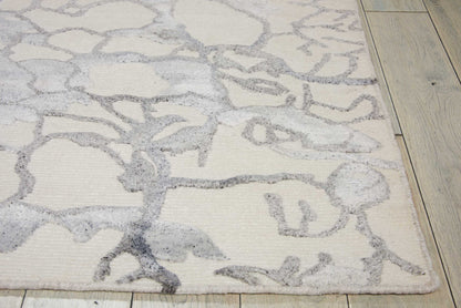 Cream rectangular area rug with light gray abstract branch pattern; plush pile, modern living room accessory.