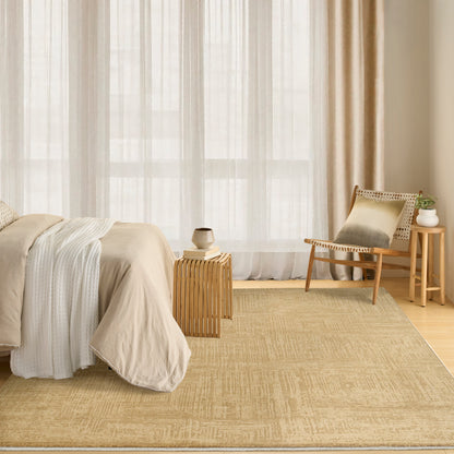 Neutral-toned bedroom with beige linens, natural fiber rug, light wood furniture, sheer curtains and a woven chair.