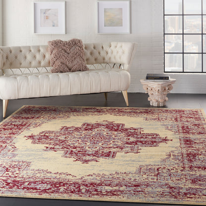 Vintage red patterned rug 7' x 10' on a floor in a living room scene with cream tufted sofa, pale legs, white brick wall, framed art and carved table.