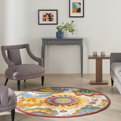 Round floral rug in orange, blue, yellow; gray console table with drawers; purple upholstered chairs in a modern living room.