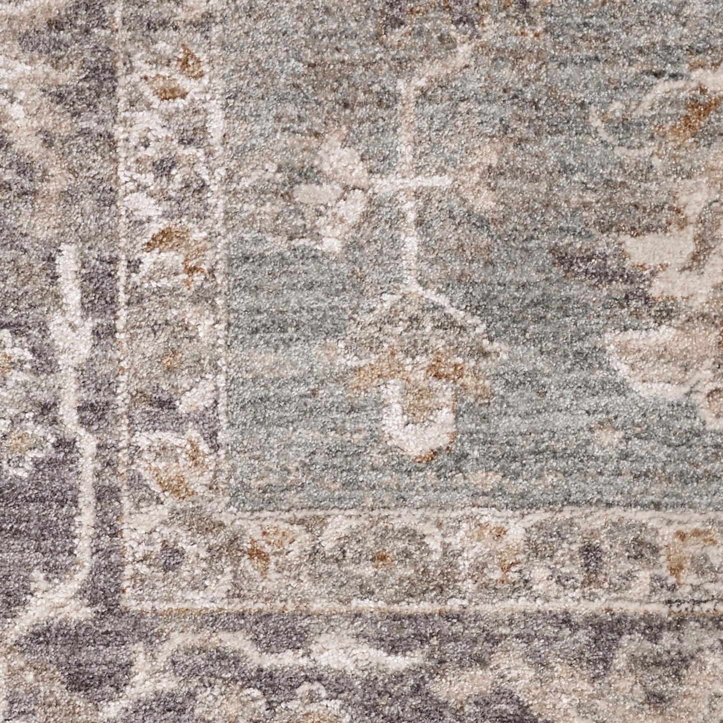 Close-up of a traditional gray-blue oriental rug with ivory floral border and medallion motifs.