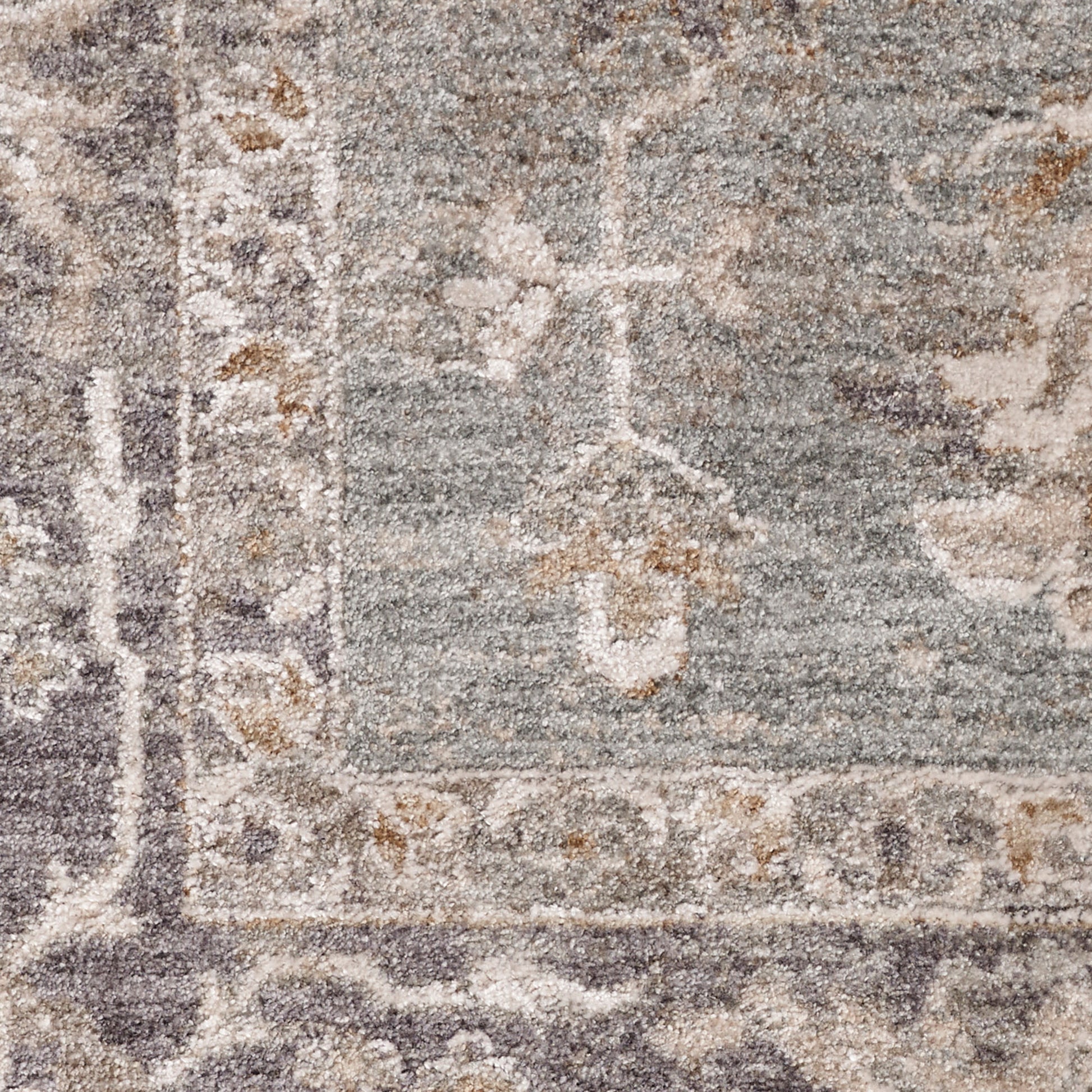 Close-up of a traditional gray-blue oriental rug with ivory floral border and medallion motifs.