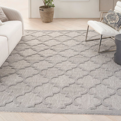 Gray area rug with interlocking quatrefoil/trellis pattern in a modern living room.