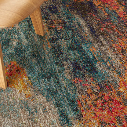 Colorful tufted rug with teal, blue, orange, pink and gray abstract pattern under a wooden table leg.