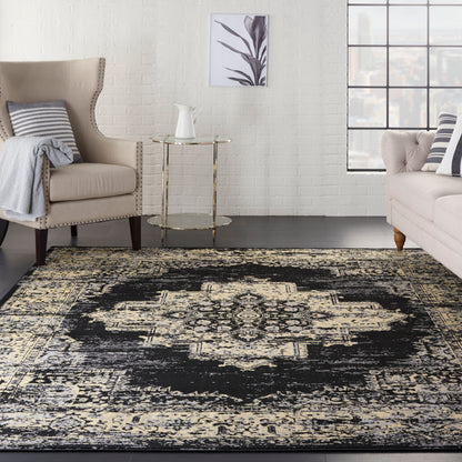 Cozy living room with beige armchair, striped cushions, glass side table, cream sofa, black-and-cream patterned rug, art.