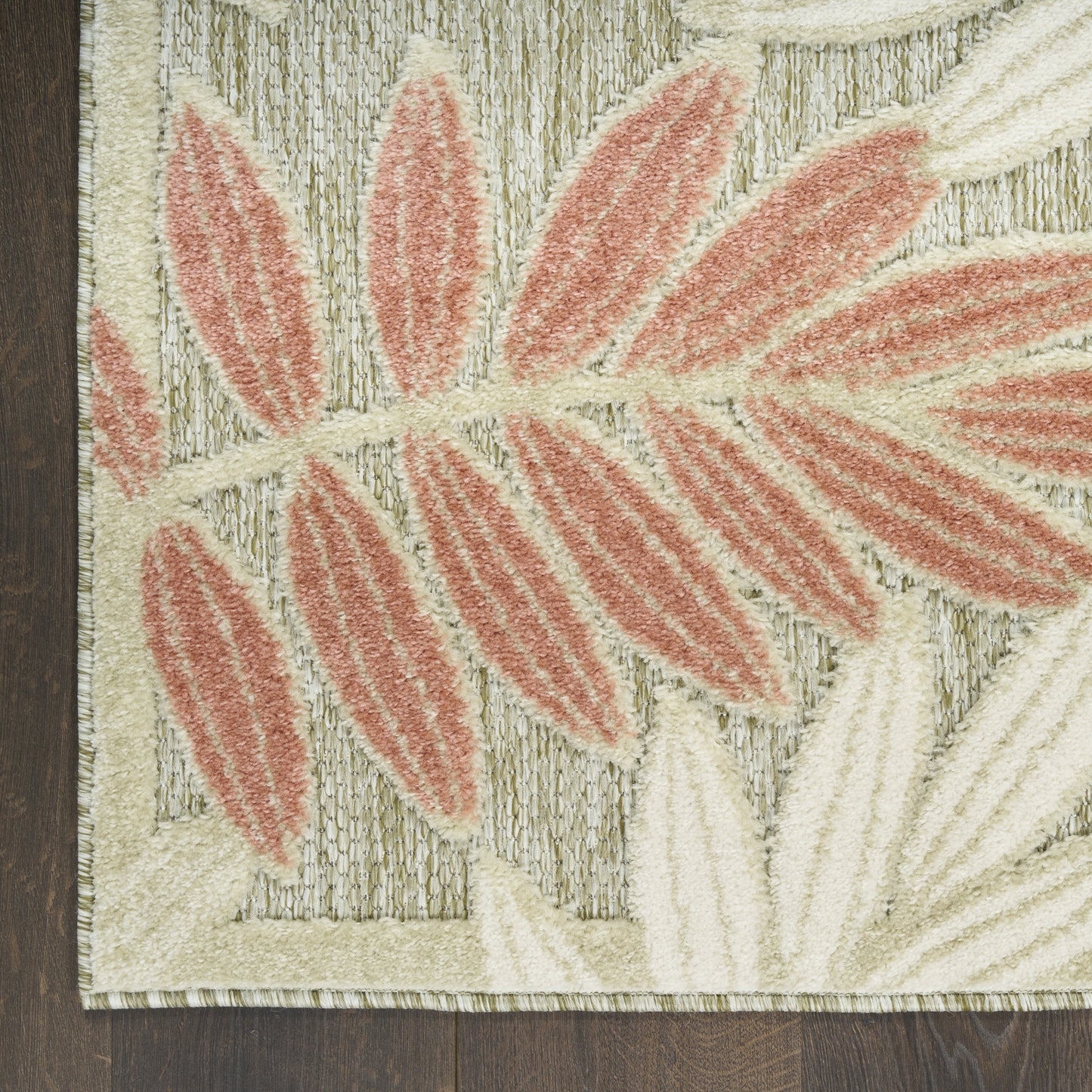 Beige rectangular rug with coral pink leaf motif, textured pile, botanical style for living room or bedroom decor.