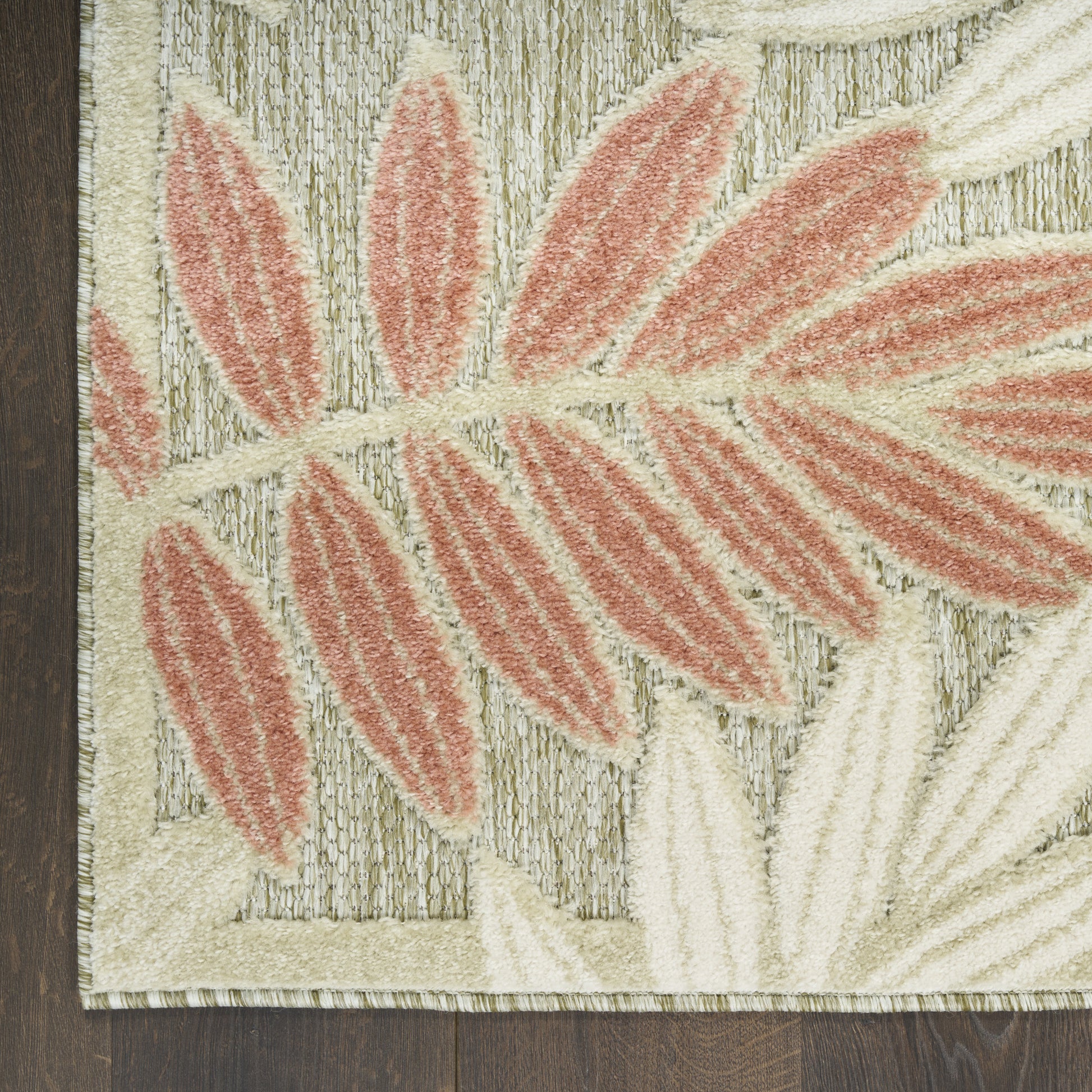 Beige rectangular rug with coral pink leaf motif, textured pile, botanical style for living room or bedroom decor.
