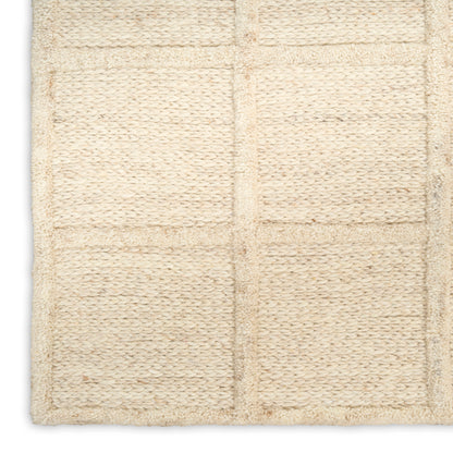 Beige woven bath mat with square grid panels in soft loop pile.