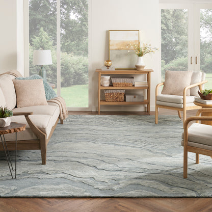 Bright living room with mid-century wood furniture, beige upholstery, blue-gray rug, wicker baskets on a console.