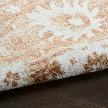 Peach and ivory floral patterned rug with soft plush pile on dark wood floor.