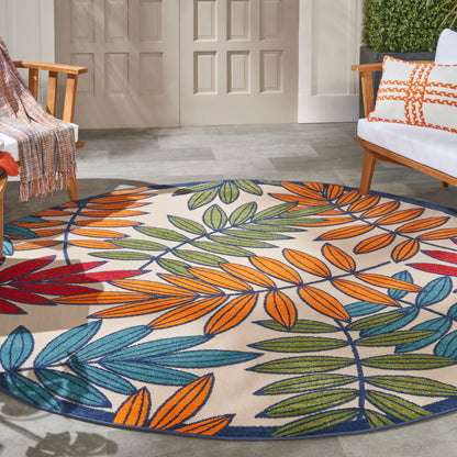 Round rug with vibrant multicolor leaf pattern (orange, green, blue) on a porch, flanked by wooden chairs.