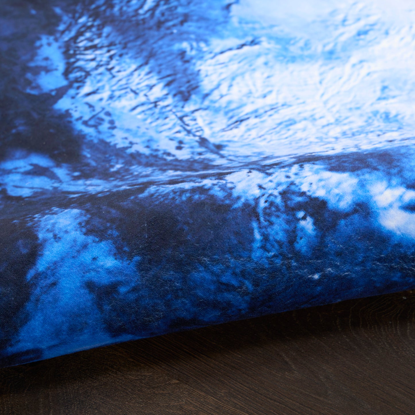 Blue marbled rug with navy & azure tones, round shape with folded edge.