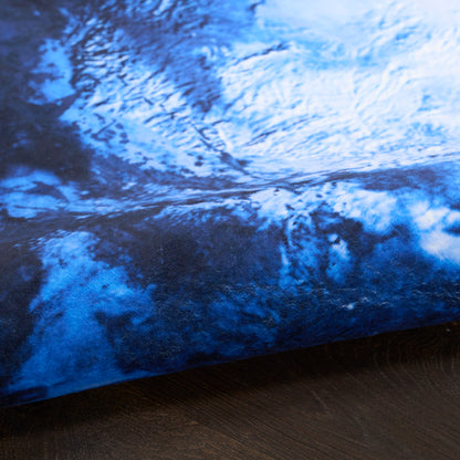 Blue marbled rug with navy & azure tones, round shape with folded edge.
