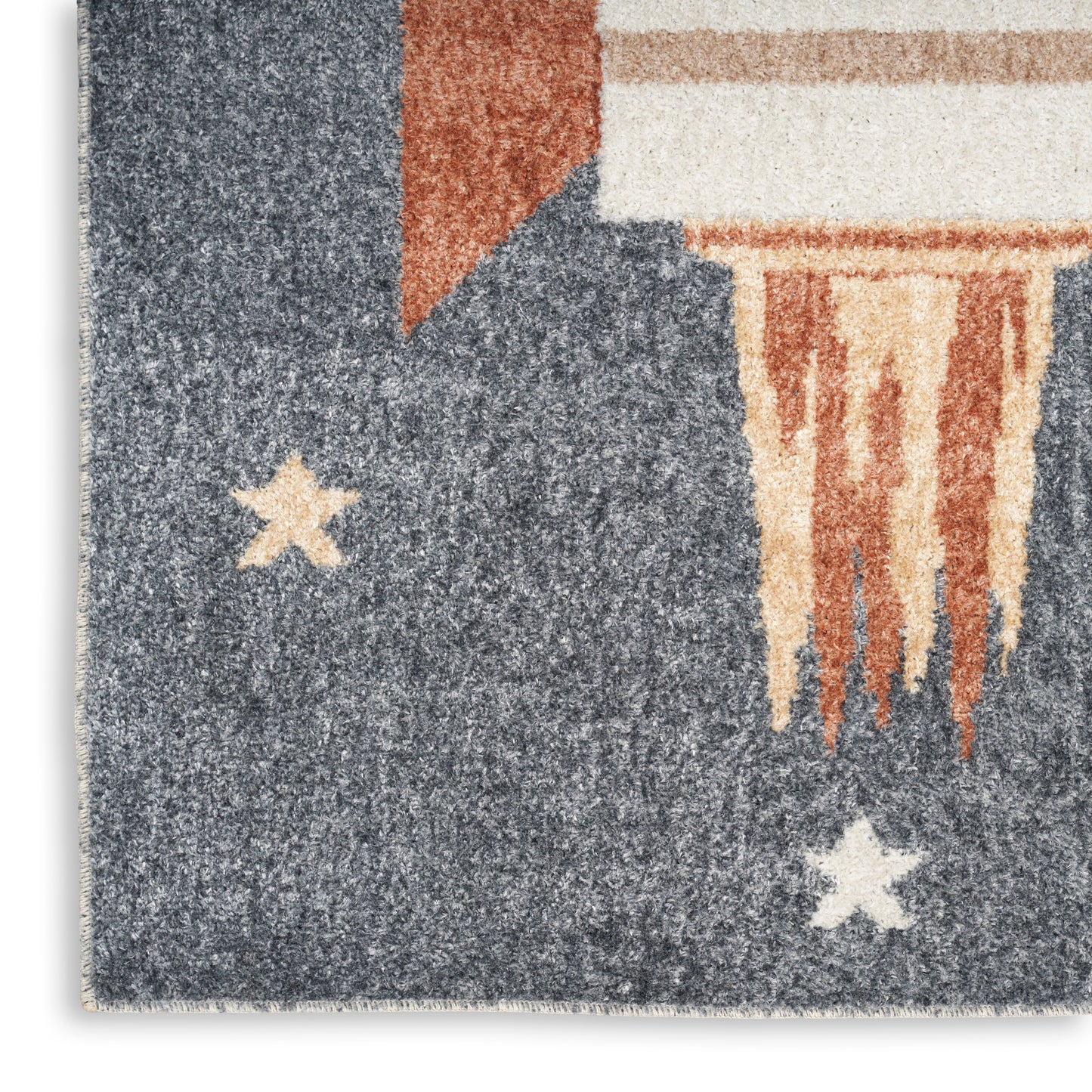 Textured blue area rug with cream stars, orange accent corner, and beige fringe in an abstract flag-inspired pattern.
