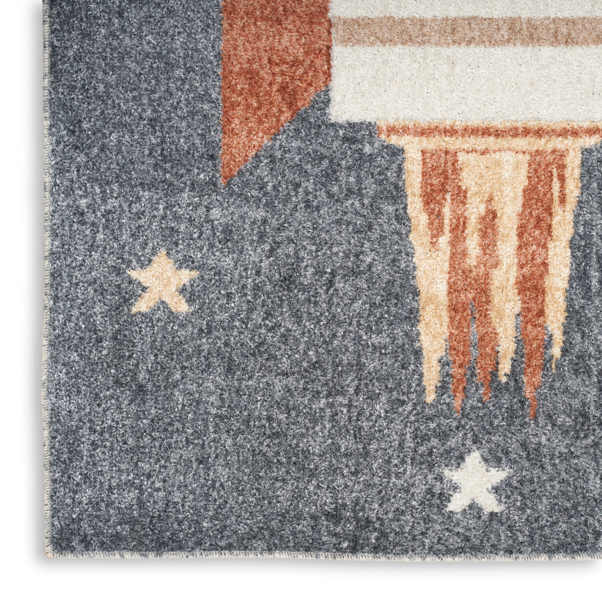 Textured blue area rug with cream stars, orange accent corner, and beige fringe in an abstract flag-inspired pattern.