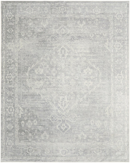Soft gray & off-white oriental-style area rug with a faded central medallion & ornate border.