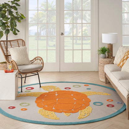 Round rug featuring a bold orange turtle motif and turquoise edge in a bright living room with wicker chair.