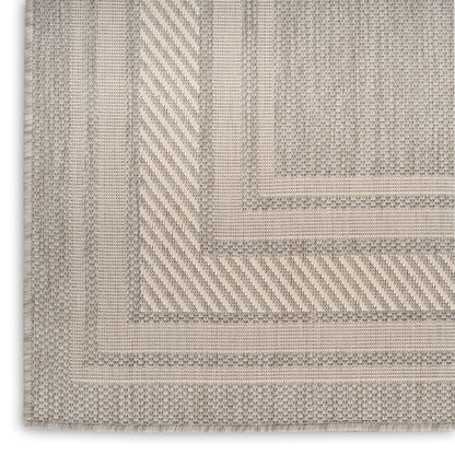Beige woven rug featuring nested rectangular borders in taupe and cream, modern textured style.