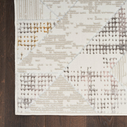 Rectangular geometric patchwork rug in cream, taupe, gray and beige on dark wood floor.