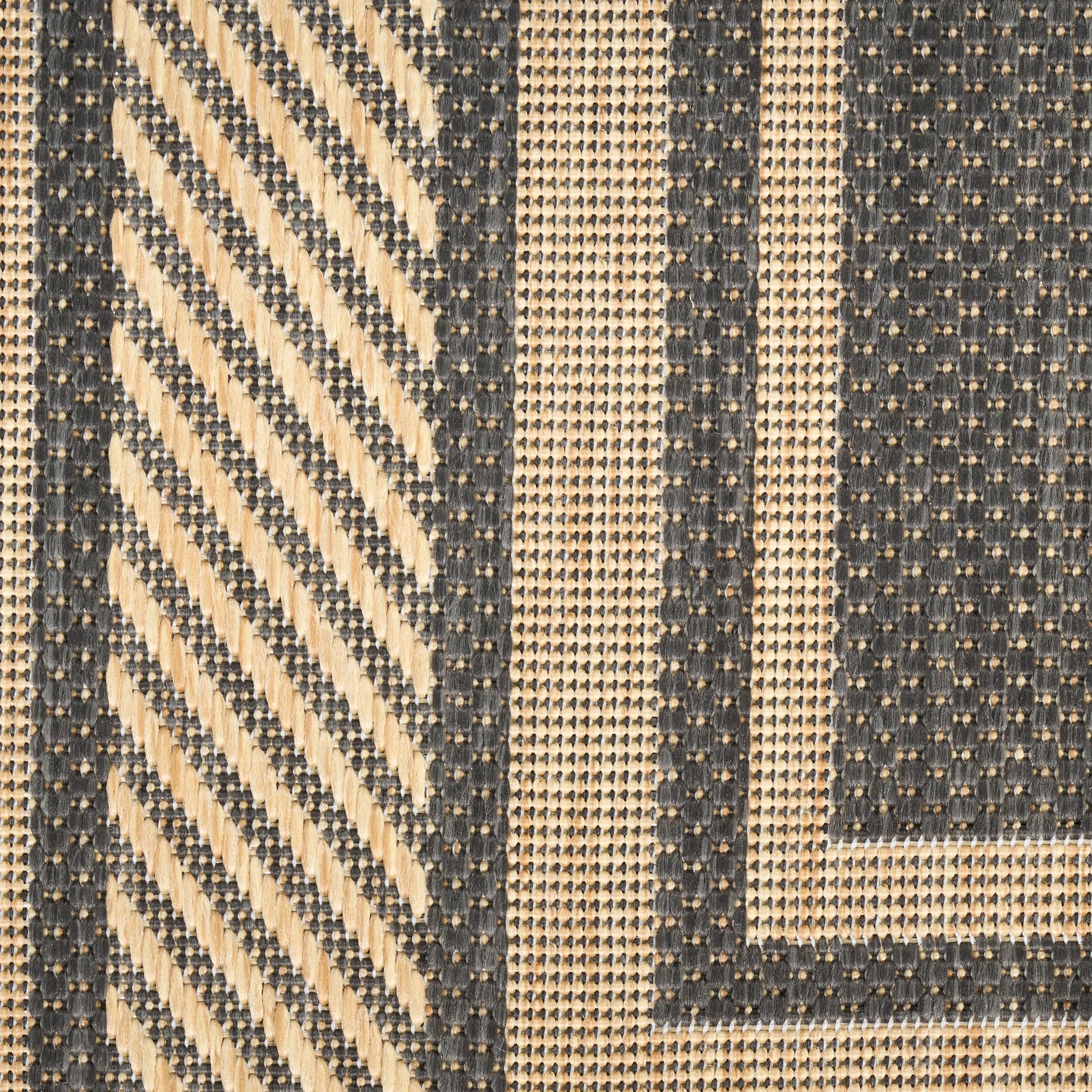 Beige and navy rug with diagonal chevron stripes and framed geometric panels; textured textile.