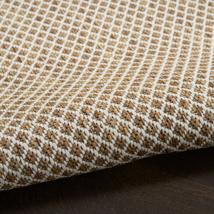 Beige and ivory woven jute rug with a diamond pattern; round 8 ft diameter on dark wood surface.