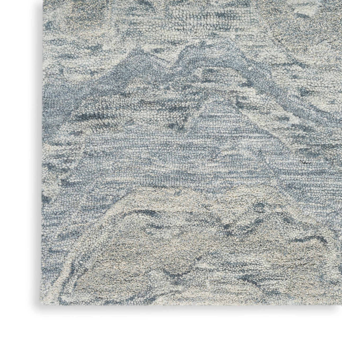 Blue-gray and ivory textured rug with abstract mountain pattern; woven, soft neutral floor decor.