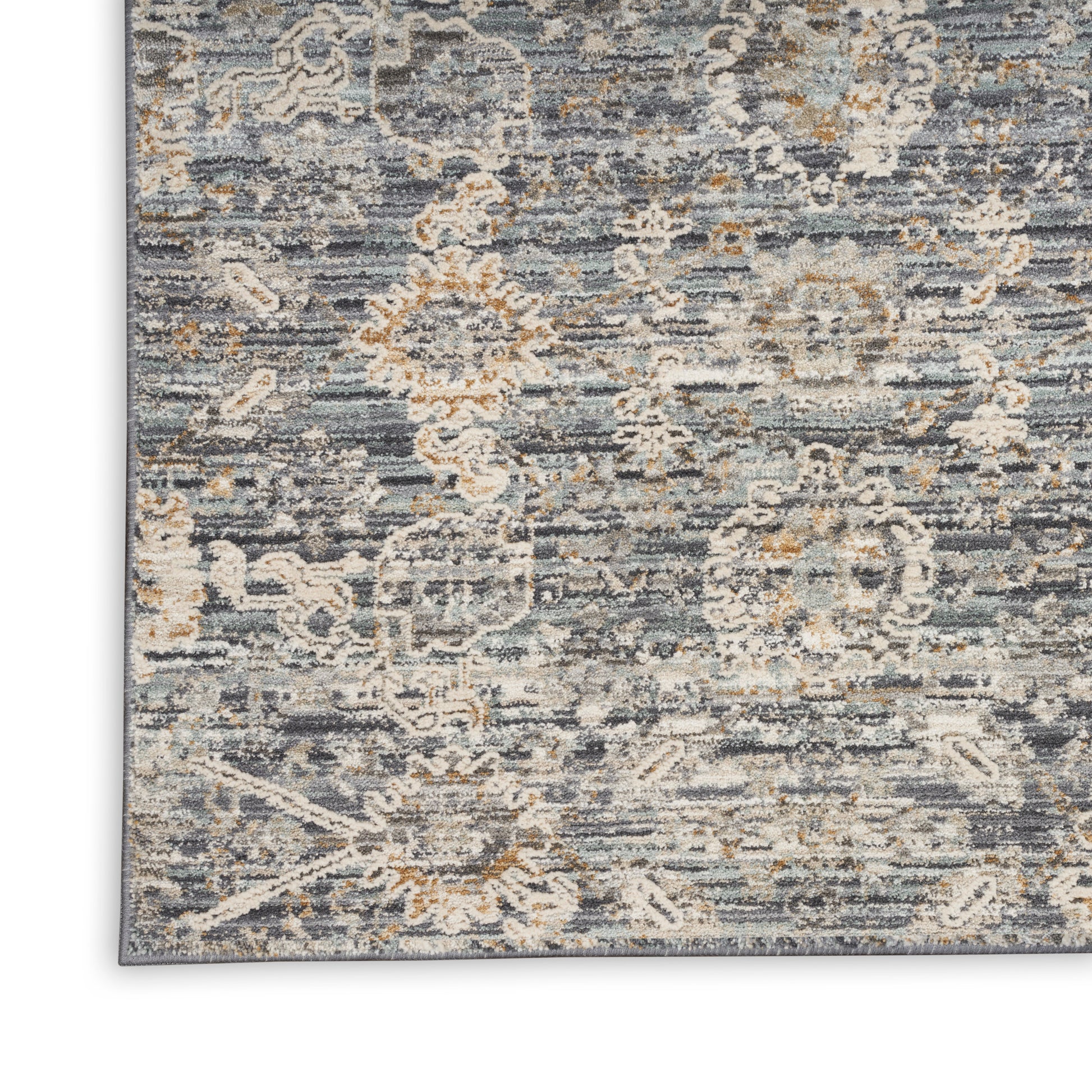 Distressed blue-gray oriental area rug with ivory floral medallions and subtle tan accents.