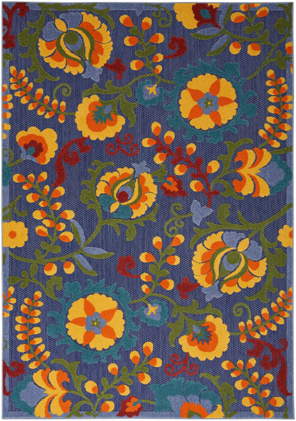 Blue woven rug with yellow and orange flowers, green and teal vines, and red accents in a scrolling floral pattern.