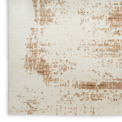 Cream beige area rug featuring irregular tan-brown distressed pattern and textured surface.
