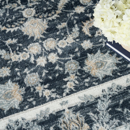 Navy blue floral patterned rug with beige/ivory accents & a light border; white hydrangea bouquet & notebook on edge.
