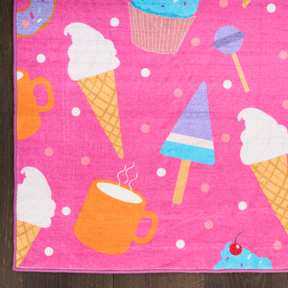 Soft pink kids rug with a dessert-print pattern featuring ice cream cones, cupcakes, mugs, popsicles and sprinkles.