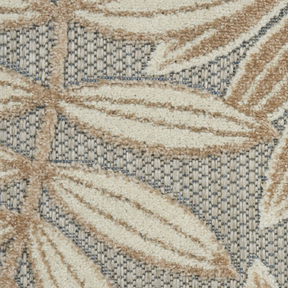 Beige leaf pattern on blue-gray textured woven rug with boucle pile.