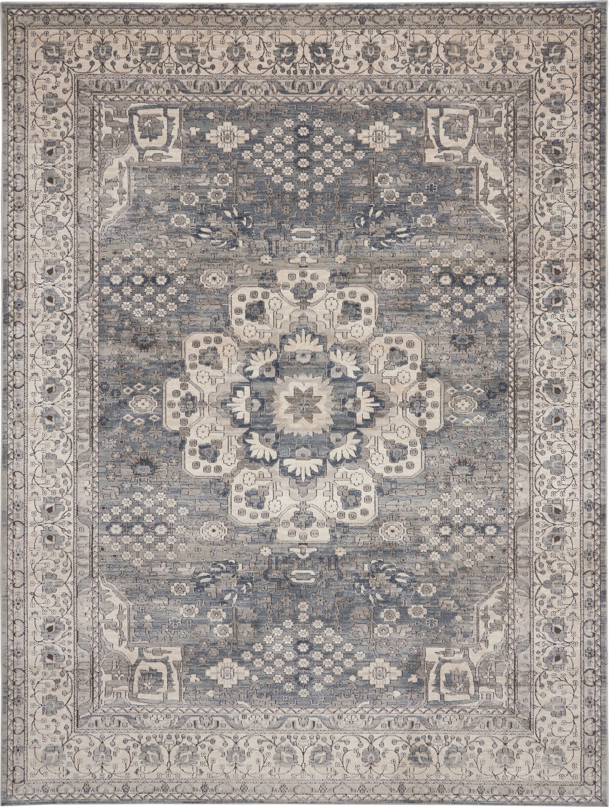 Blue-gray oriental rug with ivory central medallion, intricate floral border; distressed vintage look for living room decor.