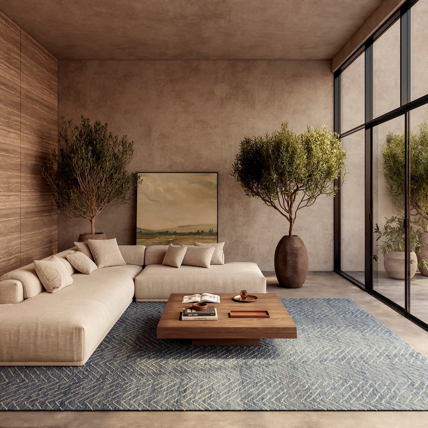 Beige sectional sofa with neutral cushions, blue zigzag rug, wooden coffee table, large potted trees, earthy walls, and glass wall windows.