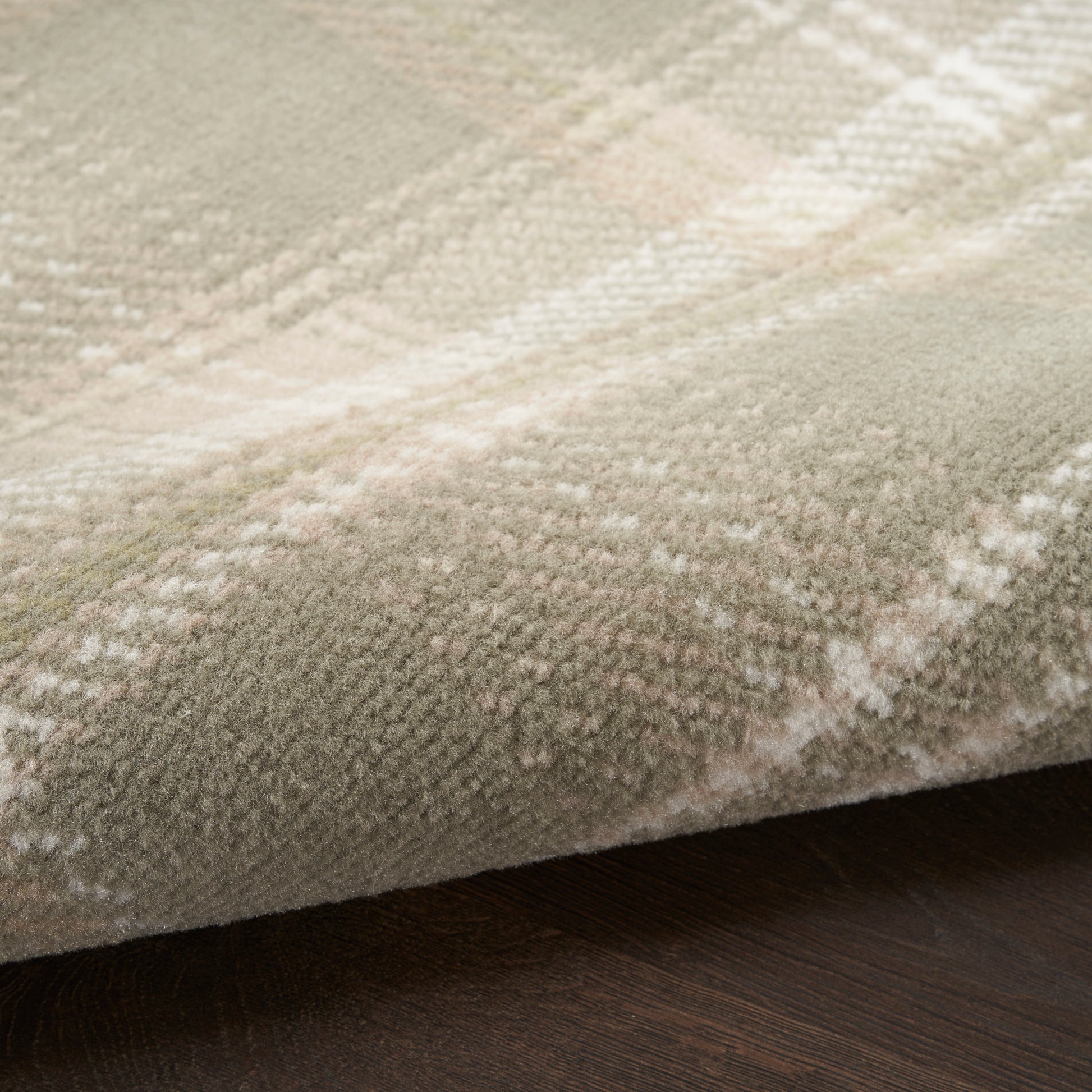 Soft beige plaid rug with plush pile, resting on dark wood flooring.