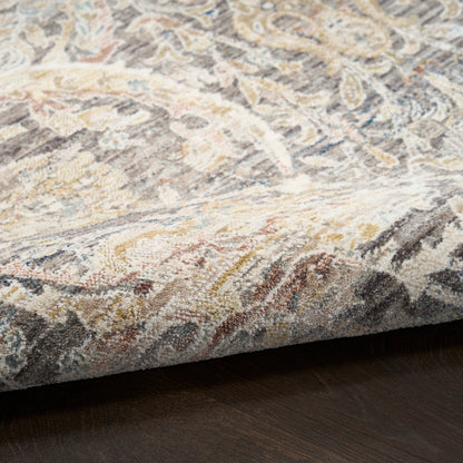 Oriental patterned area rug in cream, gray, blue & gold tones on dark wood floor; medium-pile, decorative accent.