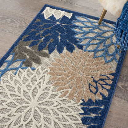 Decorative area rug with large floral mandala motifs in navy, ivory, beige & gray on a blue border.