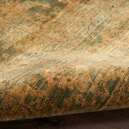 Vintage oriental rug close-up: green, gold and rust tones with floral pattern and rolled edge on dark wood floor.