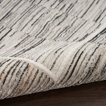 Beige textured rug with dark gray stripes, plush loop pile, folded edge on dark wood floor.