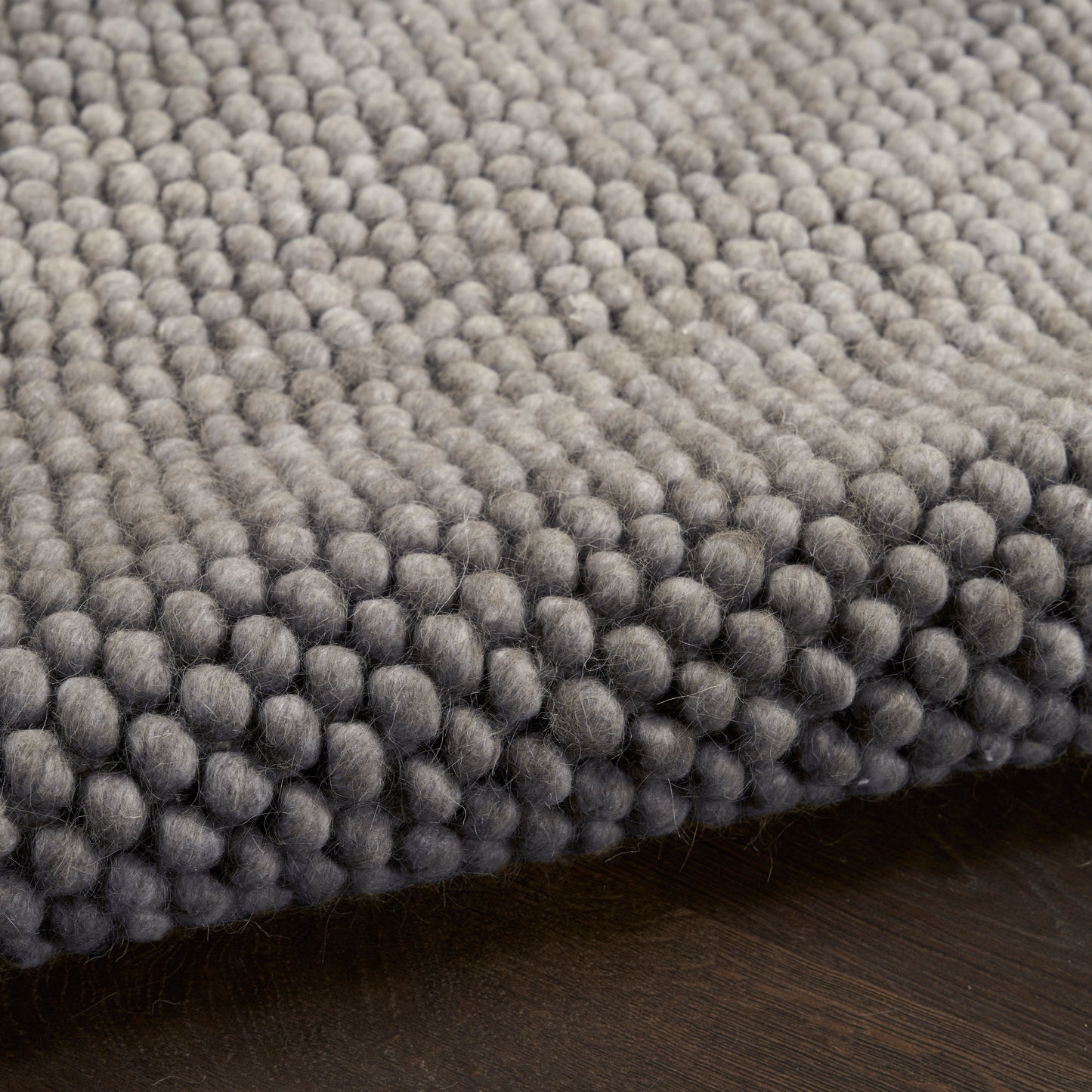Gray boucle loop-pile rug with dense, rounded tufts; modern, cozy floor covering for living spaces.