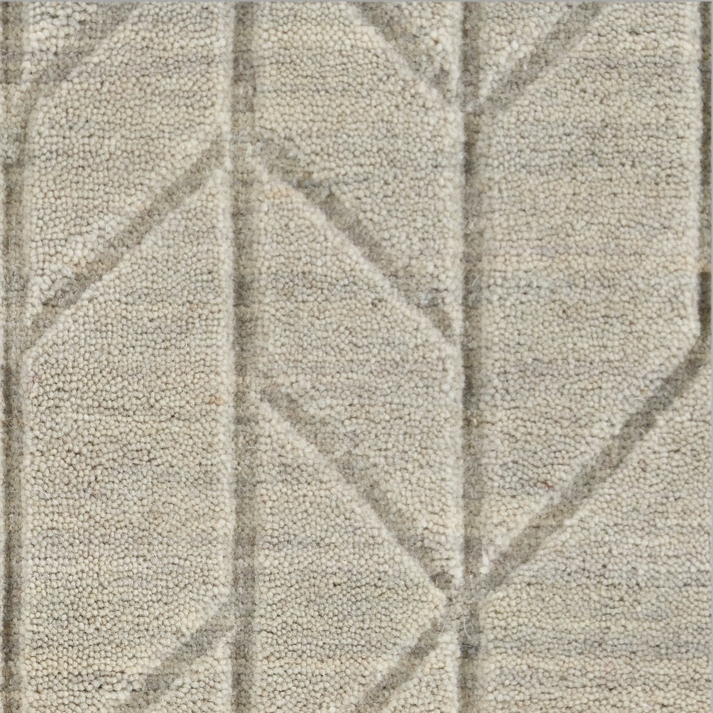 Beige shag rug close-up with muted gray geometric lines forming diamonds; plush pile, neutral decor.