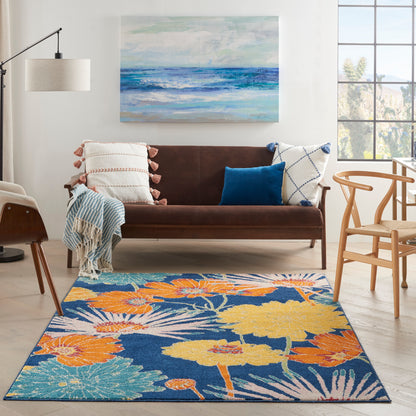 Rectangular area rug with bright floral pattern in orange, yellow, blue and teal; modern living room.