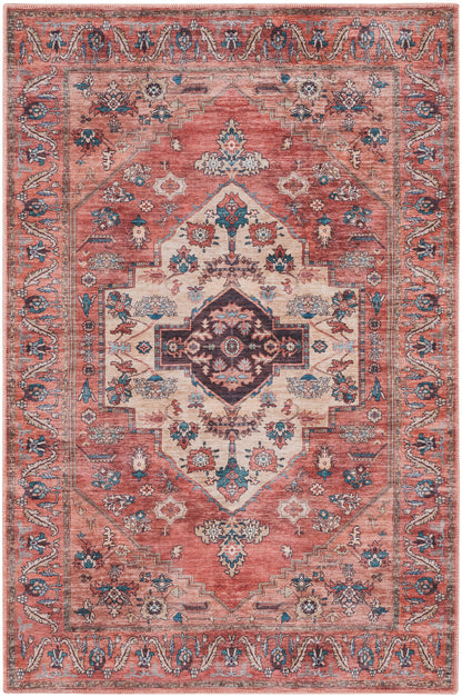 Rectangular coral-pink oriental rug with ivory central field, navy diamond medallion, and blue floral border.