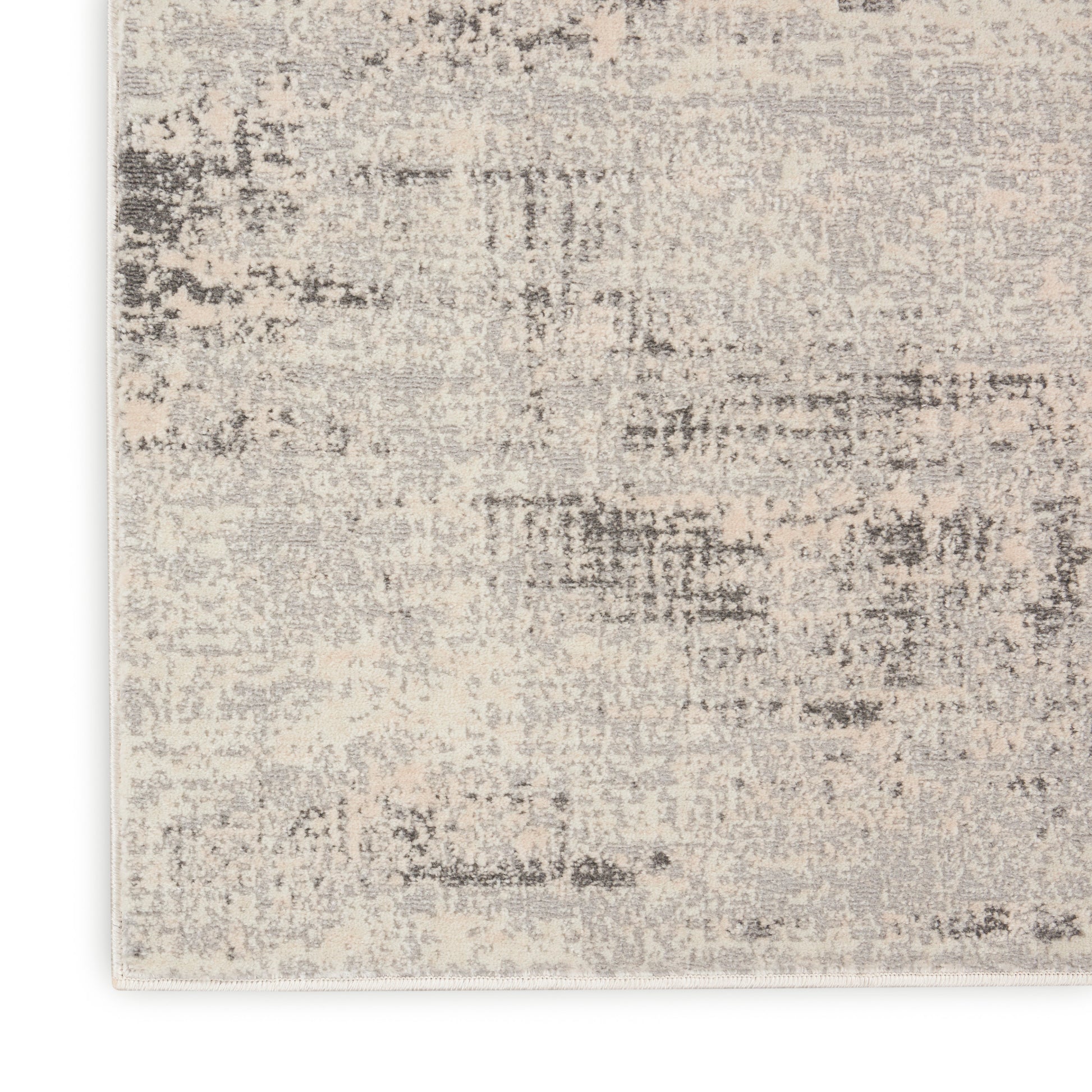 Abstract beige and gray distressed area rug with soft, low-pile, mottled texture.