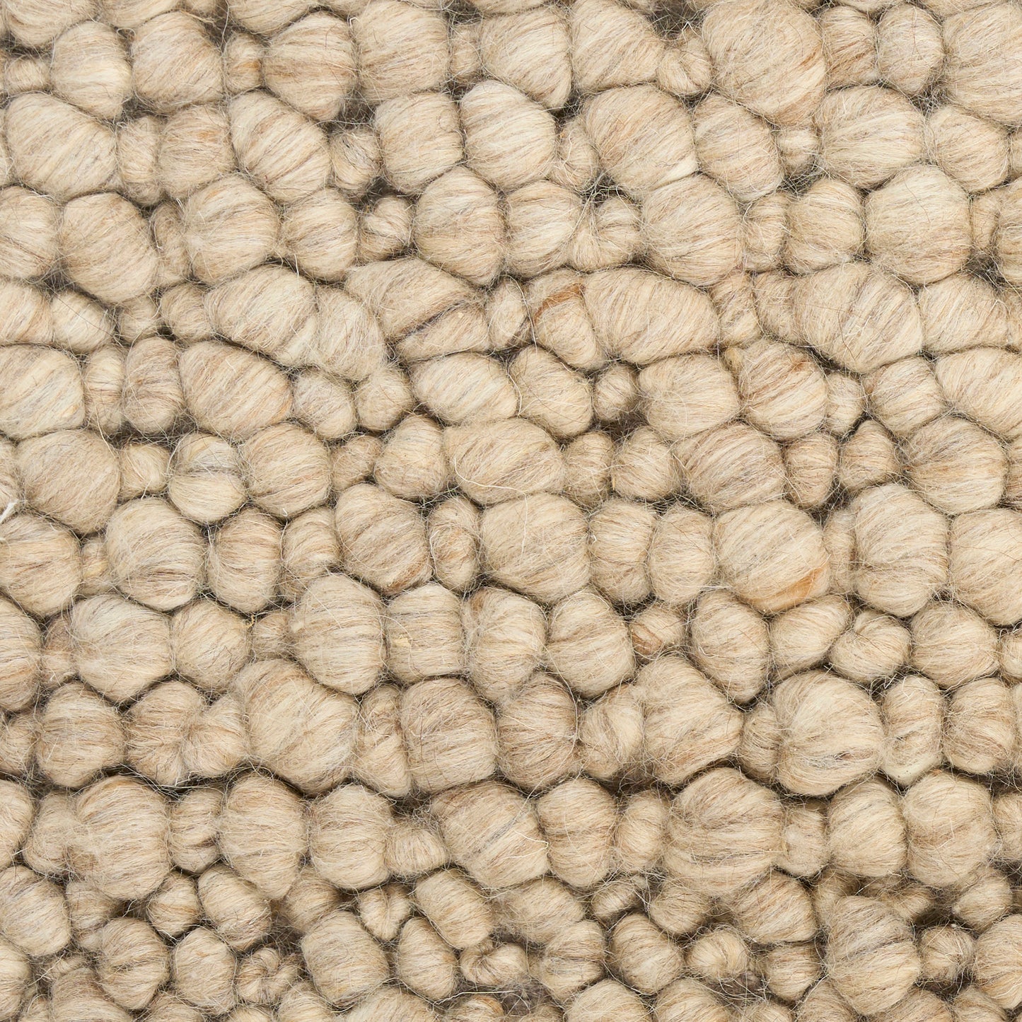 Beige boucle wool rug close-up with chunky looped tufts and textured surface.