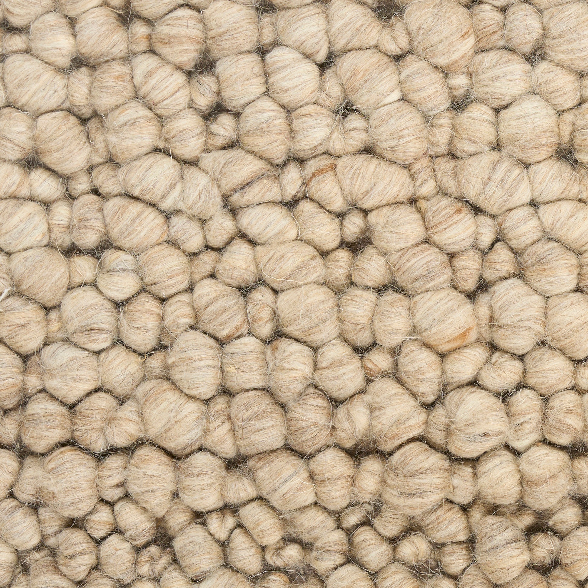 Beige boucle wool rug close-up with chunky looped tufts and textured surface.